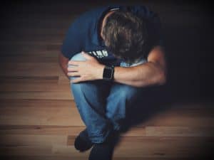 Man sitting on the floor holding his led in pain