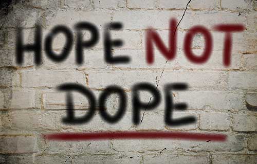 A graffiti on a wall saying "Hope Not Dope"