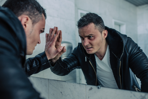 man looking into mirror at himself