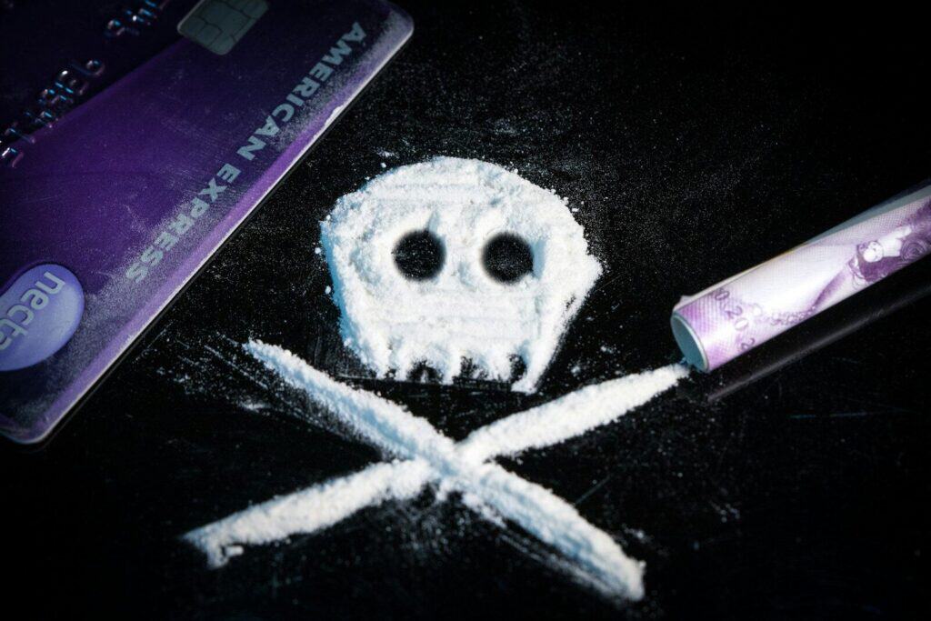 A skull and crossbones shape made of white powder on a black surface